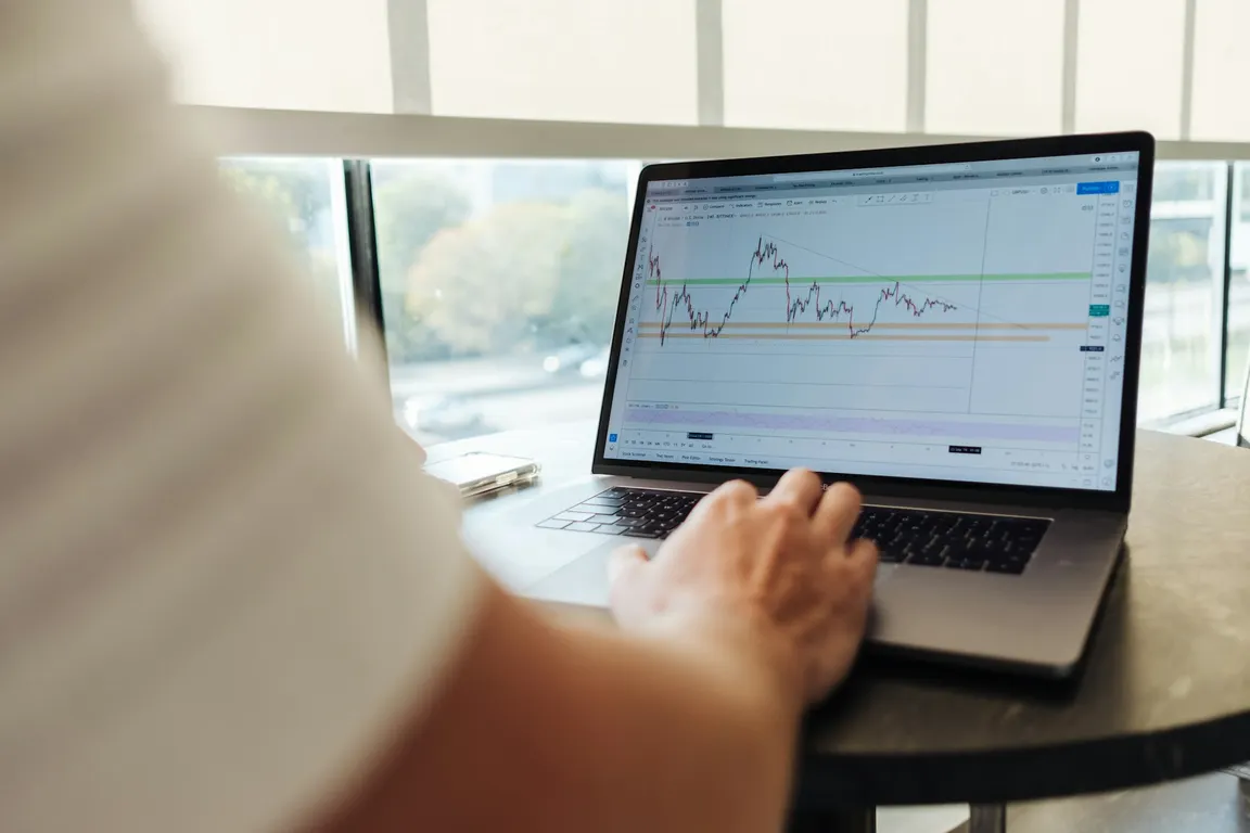 A person looking at a trading chart on a computer screen